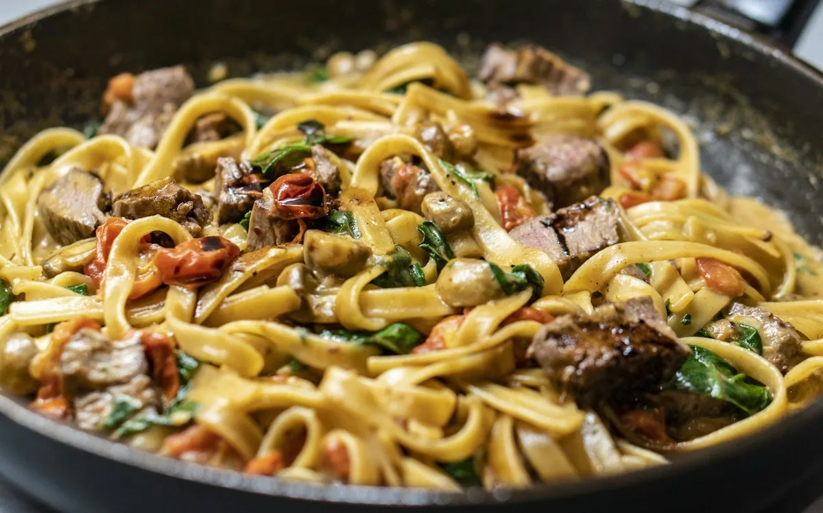 Tagliatelle fatte in casa con ragù, un piatto della cucina di Osteria del Borgo
